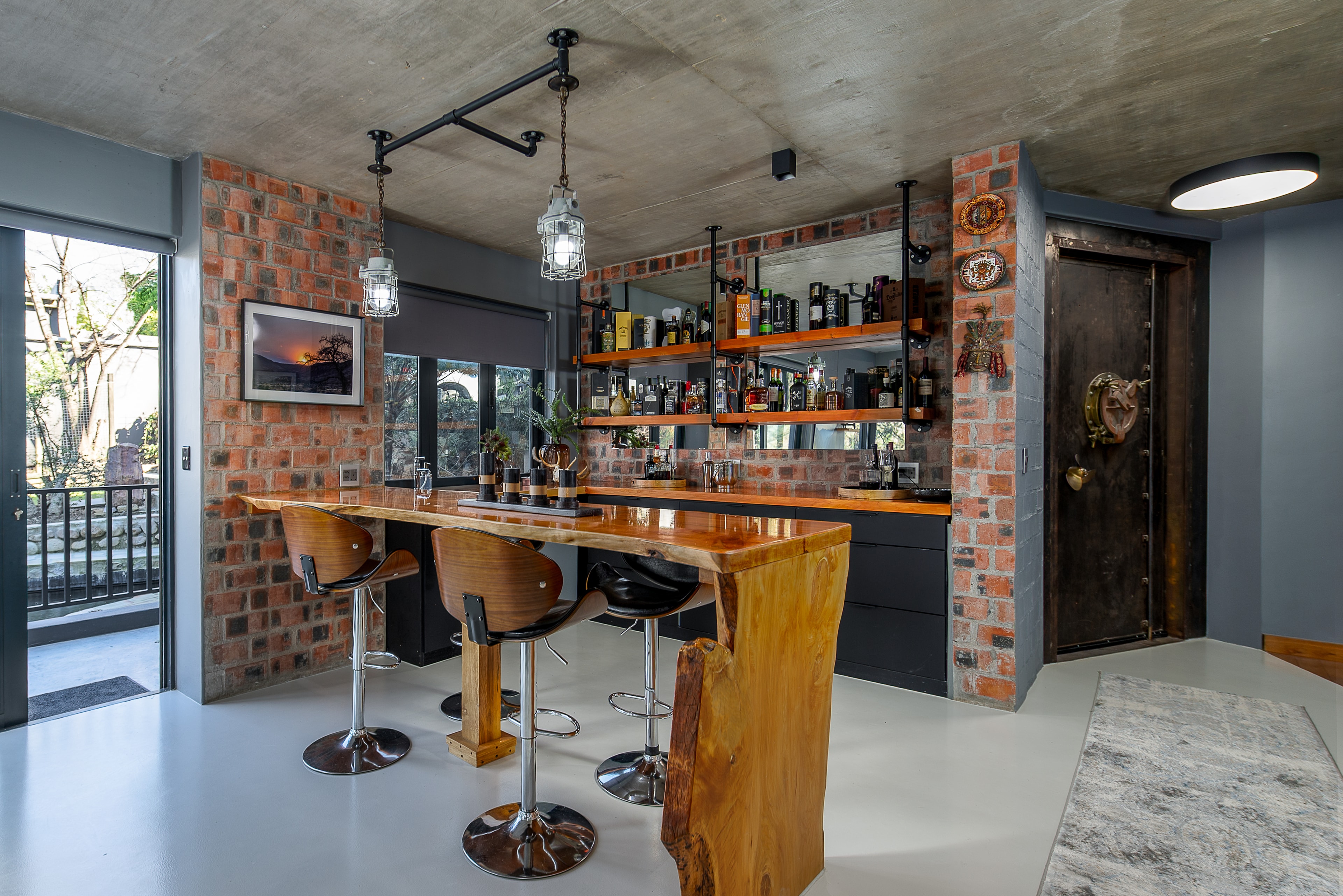 Bar counter detail — live-edge timber and shelved spirits