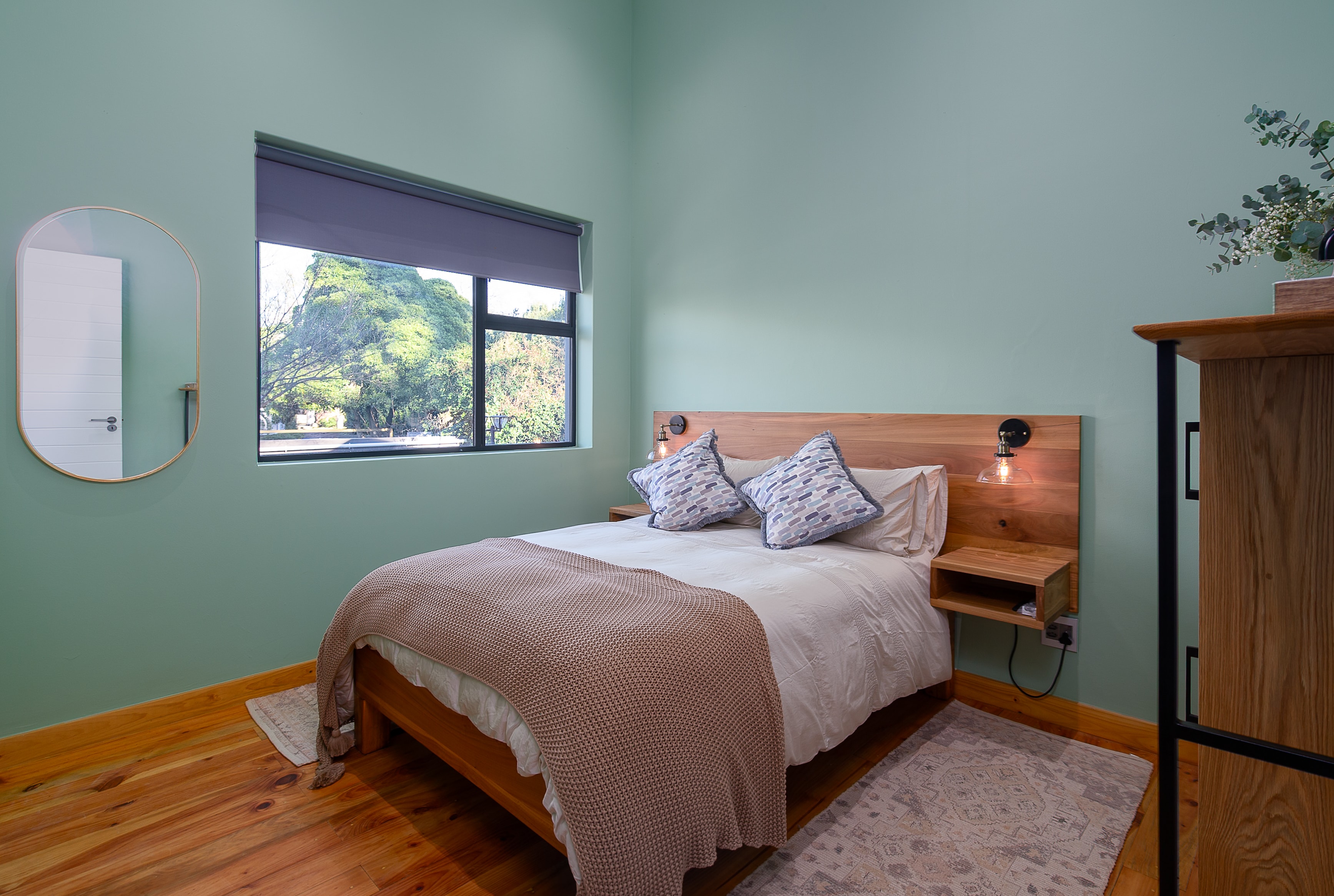 Bedroom with sage green walls and timber floors